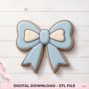 May include: A bow-shaped cookie decorated with light blue and cream-colored icing, featuring dark grey piping outlines. The design includes a central knot and two hanging ribbon tails. The text DIGITAL DOWNLOAD - STL FILE is at the bottom.