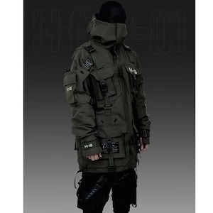 Puede incluir: Chaqueta t&aacute;ctica verde oliva con m&uacute;ltiples bolsillos, correas y cuello alto. La chaqueta presenta el texto "H-G" en varios bolsillos y un gorro negro. La chaqueta forma parte de una l&iacute;nea de ropa futurista o de inspiraci&oacute;n militar.