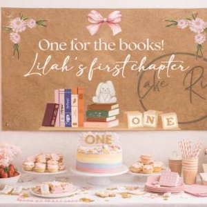 May include: A party scene with pink and gold decorations, balloons, and a cake. A banner reads "One for the books! Lilah's first chapter." A cake with a rainbow design sits on a white cake stand. Other treats and gifts are on the table.