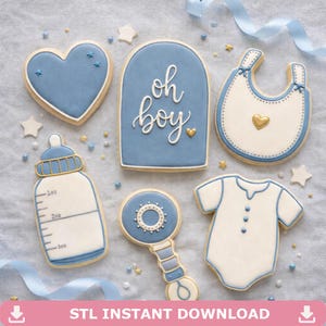 May include: A selection of baby-themed biscuits, including a heart, bib, onesie, bottle, and rattle. The biscuits are decorated with blue and white icing, with the phrase "oh boy" on one. Gold and star-shaped sprinkles are scattered around.