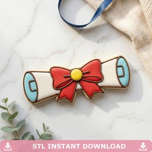 May include: A decorated cookie in the shape of a scroll with a red bow and yellow center. The scroll is white with blue accents and brown outlines. The text "STL INSTANT DOWNLOAD" is at the bottom.