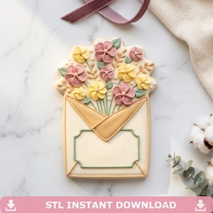 May include: A decorated sugar cookie shaped like an envelope overflowing with pink and yellow flowers. The cookie has a cream-coloured base with a tan envelope design and a green border. The text "STL INSTANT DOWNLOAD" is at the bottom.