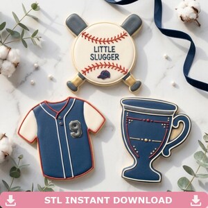 May include: Three decorated sugar cookies featuring a baseball with crossed bats and the text LITTLE SLUGGER, a navy and white baseball jersey with the number 9, and a navy blue trophy cup with red and white accents, all with detailed icing.