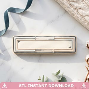 May include: A rectangular cookie cutter with a cream-coloured centre and a grey and black border. The cookie cutter has a rectangular shape with a blank space in the middle. The text "STL INSTANT DOWNLOAD" is at the bottom of the image.