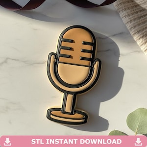 May include: A beige microphone-shaped cookie with black outlines and details. The cookie has a rounded top with horizontal lines and a curved base. The text "STL INSTANT DOWNLOAD" is at the bottom of the image.