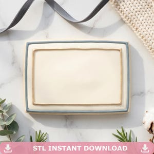 May include: A rectangular, cream-coloured ceramic tray with a pale blue border and a gold-coloured inner rim. The tray is set on a marble surface, with sprigs of greenery and a grey ribbon in the background. Text at the bottom reads "STL INSTANT DOWNLOAD".