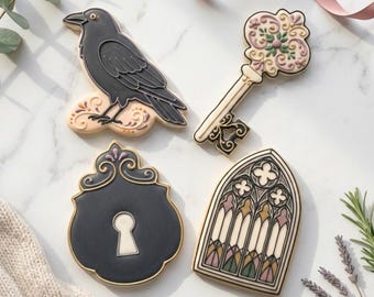 May include: Four intricately decorated cookies: a black raven, a key with floral accents, a black shield with a keyhole, and a stained-glass window design. The cookies are on a marble surface. Text at the bottom reads "STL INSTANT DOWNLOAD".