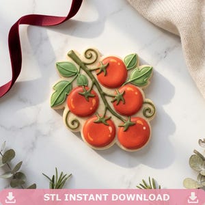 May include: A decorated sugar cookie shaped like a cluster of tomatoes on a vine, with green leaves and stems. The tomatoes are red with a gradient effect. The cookie has the text "STL INSTANT DOWNLOAD" at the bottom.