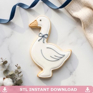 Puede incluir: Una galleta con forma de ganso blanco con un lazo y detalles en azul claro. La galleta tiene un pico marrón claro y está decorada con líneas azules claras. Las palabras "STL INSTANT DOWNLOAD" están en la parte inferior de la imagen.
