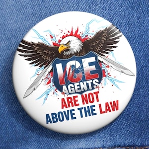 Puede incluir: Un botón blanco con un diseño patriótico que presenta un águila, rayos y el texto "ICE AGENTS ARE NOT ABOVE THE LAW". El botón está sobre un fondo de mezclilla azul.