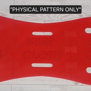 May include: A bright red burp cloth pattern with the words "BURP CLOTH" embossed on the surface. The cloth has an hourglass shape with several rectangular cutouts. The text "PHYSICAL PATTERN ONLY" is at the top.