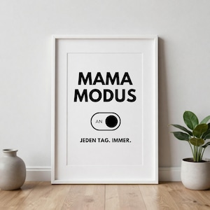May include: White framed print with the words "MAMA MODUS" in bold black letters. Below is a graphic of a switch with the word "AN" and the text "JEDEN TAG. IMMER."