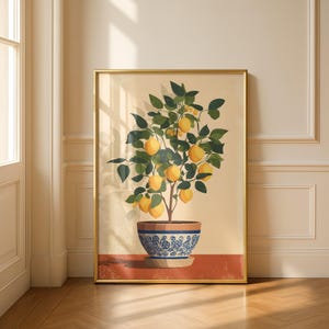 Könnte beinhalten: Ein gerahmter vertikaler Kunstdruck, der einen Zitronenbaum im Topf mit leuchtend gelben Früchten und dunkelgrünen Blättern zeigt. Die Pflanze steht in einem runden, blau-weiß gemusterten Keramiktopf mit terrakottafarbenem Boden vor cremefarbenem Grund.