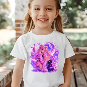 Könnte beinhalten: Weißes T-Shirt mit einer farbenfrohen Illustration im Anime-Stil. Die Grafik zeigt ein Mädchen mit rosa Haaren, eine schwarze Katze und einen Mond mit Sternen. Das Design ist in Lila-, Rosa- und Blautönen gehalten.