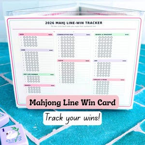 May include: A 2026 Mahj Line-Win Tracker card in a clear plastic stand. The white card features colorful sections for tracking wins in categories like Consecutive Run, Winds & Dragons, 2468, 13579, 369, Any Like Number, and Quints, with rows of circles.