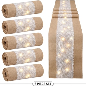 May include: A set of six rolled burlap table runners with a white lace overlay and string lights. The table runners are displayed alongside a single, unfolded runner. The text "6 PIECE SET" is at the bottom.