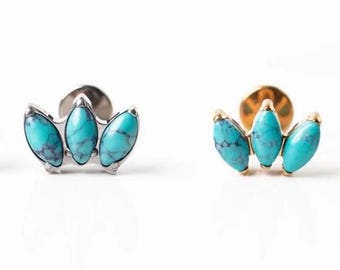 May include: Two stud earrings with a turquoise stone design. One earring has a silver setting, and the other has a gold setting. Each earring features three oval-shaped, light blue stones with dark blue veining.