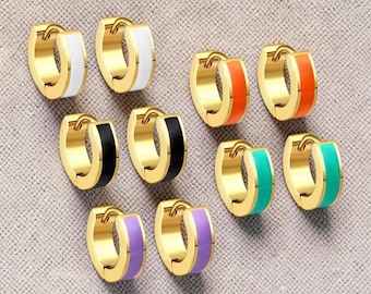 May include: Gold-tone hoop earrings with colorful enamel accents. The earrings feature a variety of colors, including white, orange, black, teal, and purple. These earrings are a stylish accessory for everyday wear.
