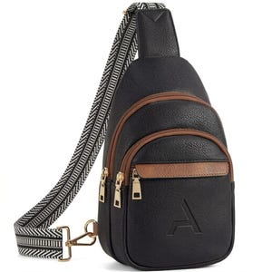 May include: Black sling bag with brown detailing and gold-coloured zips. The bag has a patterned strap and a debossed letter "A" on the front. Designed to be worn across the body.