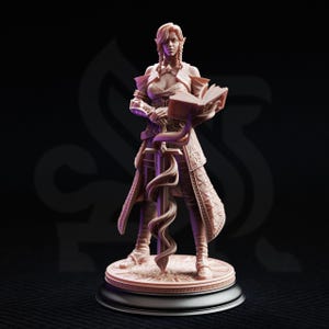 Könnte beinhalten: Eine helle, unbemalte Miniaturfigur aus Kunstharz, die einen elfenartigen Charakter auf einem runden Sockel darstellt. Die Figur trägt eine detaillierte Rüstung, hält ein offenes Buch und stützt die andere Hand auf ein von Ranken umwundenes Schwert.