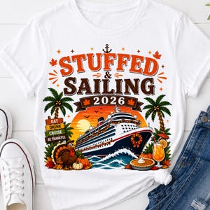 Peut inclure: Un t-shirt blanc à manches courtes avec une impression graphique portant le texte STUFFED & SAILING 2026. Le motif comprend un navire de croisière, des palmiers, une dinde, une citrouille, une part de tarte et un verre de boisson orange.