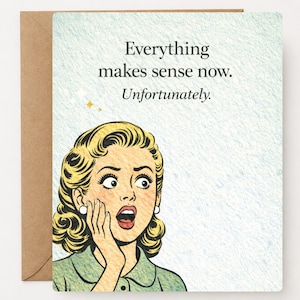 May include: Greeting card with a vintage comic-style illustration of a woman with wide eyes and an open mouth. The card has the text "Everything makes sense now. Unfortunately." The card is on a brown envelope.