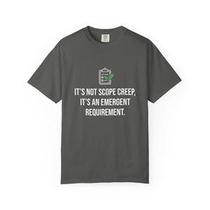 Könnte beinhalten: Ein dunkelgraues Kurzarm-T-Shirt mit einer weißen Grafik eines Klemmbretts und einem grünen Blattsymbol. Unter dem Symbol steht der Text: IT'S NOT SCOPE CREEP, IT'S AN EMERGENT REQUIREMENT. Das T-Shirt hat einen Rundhalsausschnitt.