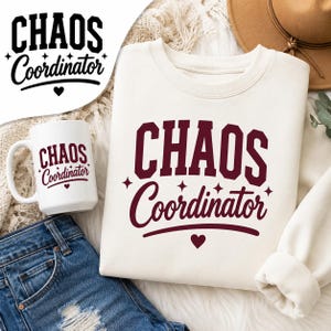 May include: A cream-colored crewneck sweatshirt and a white ceramic mug, both featuring the dark maroon text "CHAOS Coordinator" in a mix of block and script fonts, accented with small four-pointed stars and a heart symbol below the text.