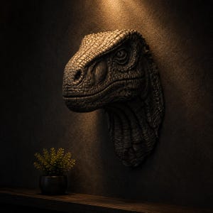 May include: A detailed, dark-colored dinosaur head sculpture mounted on a wall. The sculpture has a textured surface and is positioned above a small potted plant on a wooden shelf. The lighting highlights the intricate details of the dinosaur's face.