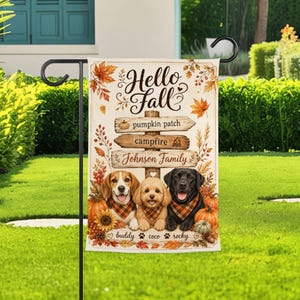 May include: A rectangular garden flag featuring the text Hello Fall, pumpkin patch, campfire, and Johnson Family on wooden signs. Three dogs wearing plaid bandanas sit below the signs, with autumn leaves, pumpkins, and the names Buddy, Coco, and Rocky.