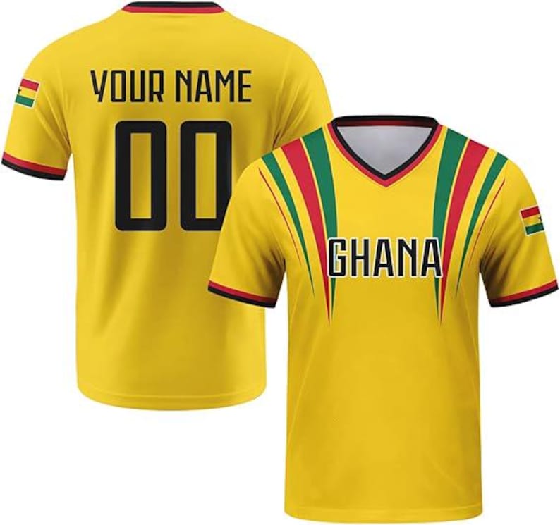 May include: A yellow short-sleeved V-neck jersey featuring the text GHANA on the front and YOUR NAME with the number 00 on the back. The design includes red, yellow, and green stripes, black trim, and the Ghana national flag on the sleeves.