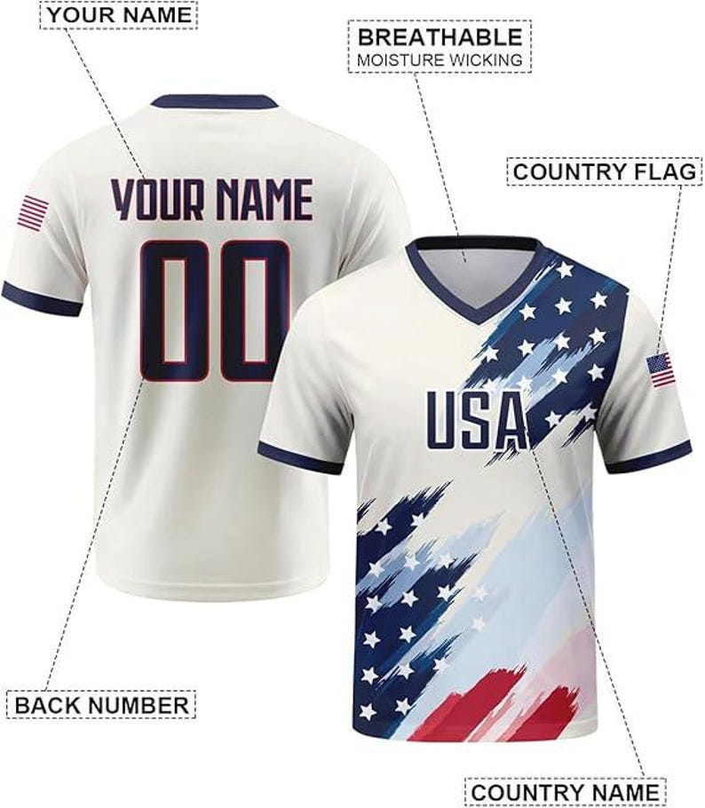 May include: A white V-neck jersey featuring a blue and red brushstroke American flag pattern on the front with the text USA. The back displays the text YOUR NAME and the number 00. Labels indicate breathable moisture wicking fabric features.