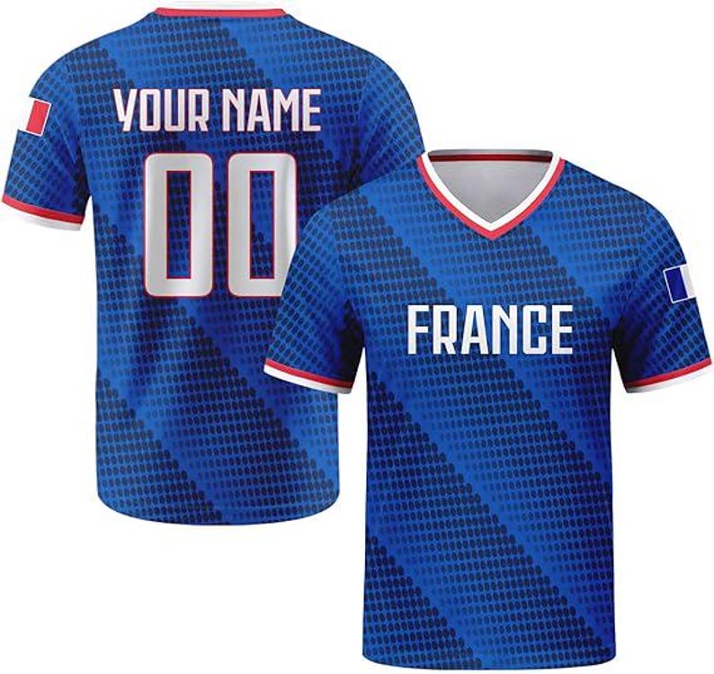 May include: A blue V-neck jersey featuring a diagonal dot pattern, white trim, and the text FRANCE on the front. The back displays the text YOUR NAME above the number 00. Both sleeves feature a small rectangular French flag patch.