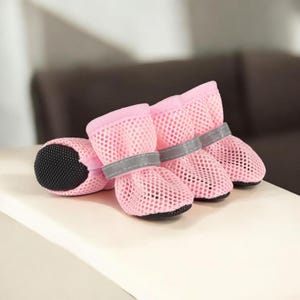 Puede incluir: Botas rosas de malla para perros con suelas negras y correas grises reflectantes. Las botas est&aacute;n dise&ntilde;adas para proteger las patas de un perro. Las botas est&aacute;n hechas de un material de malla transpirable.