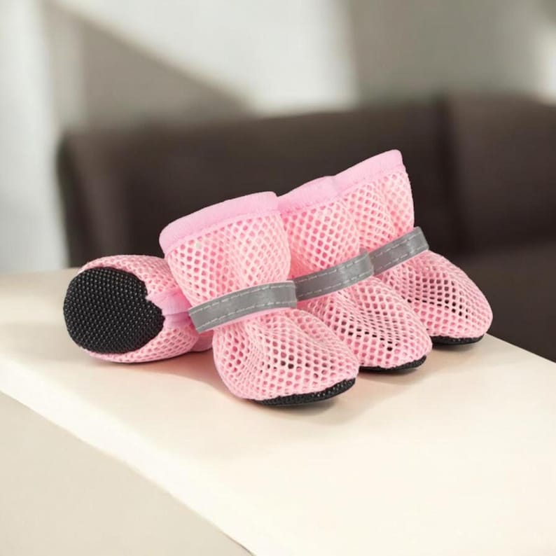 Puede incluir: Botas rosas de malla para perros con suelas negras y correas grises reflectantes. Las botas est&aacute;n dise&ntilde;adas para proteger las patas de un perro. Las botas est&aacute;n hechas de un material de malla transpirable.