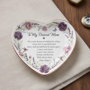 Puede incluir: Plato decorativo en forma de corazón con un diseño floral y el texto "To My Dearest Mom". El plato presenta flores moradas y rosas, colibríes y un borde dorado. El texto incluye un mensaje de amor.