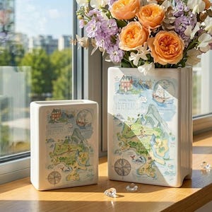 Könnte beinhalten: Eine weiße Keramik-Tasse mit schwarzem Henkel und dem Text "But First, Coffee" in fetter, schwarzer Schrift. Die Tasse steht auf einer Holzoberfläche. Die Tasse ist etwa 10 cm hoch.