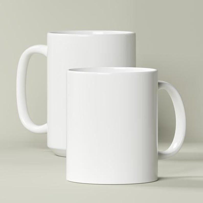 May include: Two plain white ceramic mugs of different heights, each featuring a smooth finish, a cylindrical body, and a curved handle on the side. The taller mug is positioned behind the shorter mug, both displaying a clean, solid white surface.