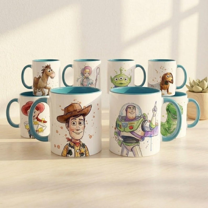 May include: A collection of eight white ceramic mugs with teal handles and rims, each featuring a unique watercolor-style illustration of a character from the Toy Story franchise, including Woody, Buzz Lightyear, Jessie, Bullseye, and others.
