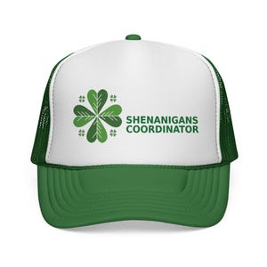 May include: A green and white trucker hat with the text "SHENANIGANS COORDINATOR". The hat has a green peak and mesh back, and a four-leaf clover design. A fun accessory.