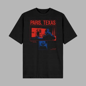 Puede incluir: Camiseta negra con un gráfico rojo y azul. El gráfico presenta el texto "PARIS, TEXAS" sobre una imagen roja y azul de una escena de la película. Debajo de la imagen hay dos imágenes más pequeñas con texto.