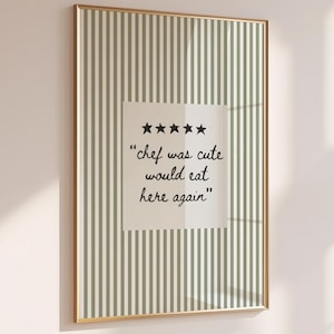 Peut inclure: Une affiche murale rectangulaire dans un cadre doré fin avec un fond à rayures verticales vert sauge et blanc. Au centre, un carré blanc affiche cinq étoiles noires et le texte noir : "chef was cute would eat here again".