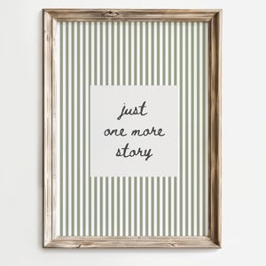 Peut inclure: Une affiche encadrée avec un cadre en bois. Le fond présente des rayures verticales vertes olive et blanches. Un carré blanc au centre affiche le texte "just one more story" dans une police manuscrite.