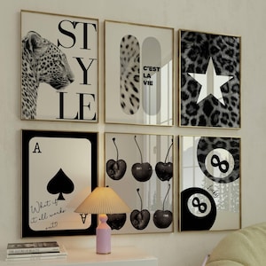 May include: A gallery wall featuring six framed art prints with gold frames. The prints include a leopard, text that says "STYLE", a leopard print with the text "C'EST LA VIE", a star on leopard print, cherries, and an eight ball.