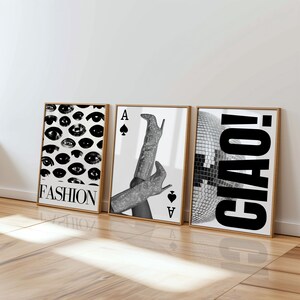 May include: A white ceramic mug with a black handle and the text "But First, Coffee" in a bold, black font. The mug is set against a blurred background, suggesting a cozy setting.