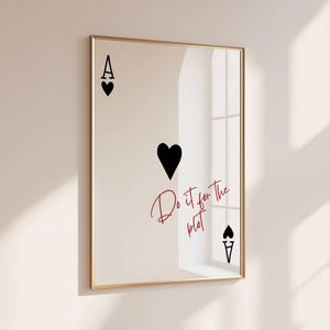 Può includere: Stampa incorniciata raffigurante l'Asso di Cuori. I simboli della carta sono neri, con la lettera "A" e un cuore in alto, un grande cuore al centro e la lettera "A" e un picche in basso. La frase "Do it for the plot" è scritta in corsivo rosso.