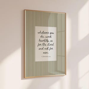 May include: A rectangular wall art print in a thin gold frame featuring a sage green and white vertical striped background. A central white rectangular block contains the black cursive text: whatever you do, work heartily, as for the Lord and not for men. Colossians 3:23.