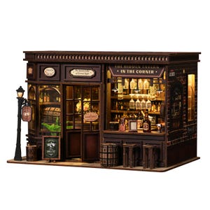 May include: A miniature wooden tavern model with a detailed facade, featuring a bar, shelves of bottles, and a sign that reads "The Hidden Tavern - In The Corner." The model includes a street lamp and a small chalkboard sign.