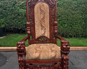 Silla de trono antigua de estilo neorrenacentista con cabezas de león talladas y escudo heráldico, sillón de respaldo alto, estilo barroco español, caoba, victoriano.