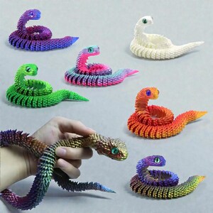 May include: A selection of brightly coloured, articulated snake toys. The snakes are in shades of purple, green, pink, orange, and white. Each has a detailed, textured body and contrasting eye colour. One snake is held in a hand.